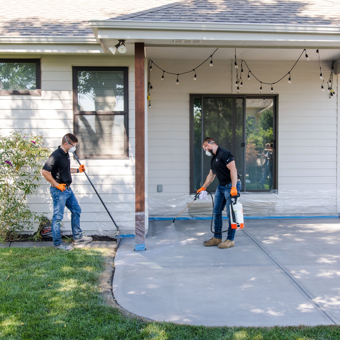 Men spraying decoshield on concrete slab