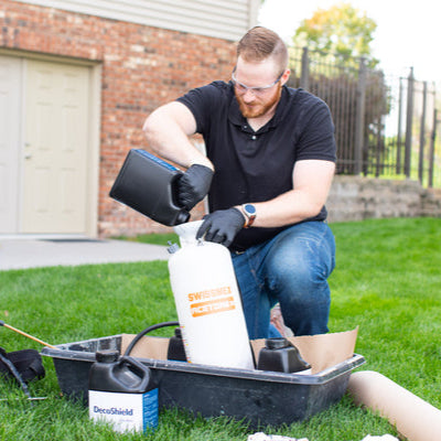 Man preparing equipment for a home improvement project outdoors.